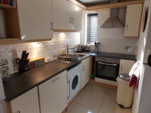 una pequeña cocina con fregadero y lavavajillas en Waterside Apartment, en Lancaster