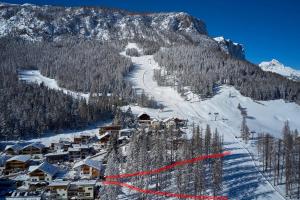 een met sneeuw bedekte berg met een skipiste met een resort bij B&B Tamarindo in La Villa