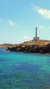 a lighthouse on a rocky island in the ocean at Cabo de Palos apartamento vacacional in Cabo de Palos