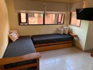 a small room with a bed and a flat screen tv at Departamentos Le Forêt in Mar de Ajó