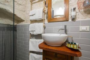 a bathroom with a sink and a mirror and towels at A Casa di Rosy in Ostuni