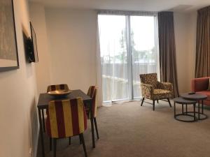 a living room filled with furniture and a table at Ramada Suites by Wyndham Manukau in Auckland