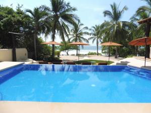 a swimming pool with a view of the beach at Casa de la Costa in Troncones