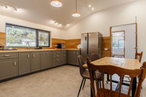 a kitchen with a table and a stainless steel refrigerator at Loft Chalet in Gura Humorului