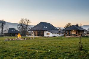 a house with a fire in a field at Loft Chalet in Gura Humorului