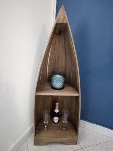 a wooden shelf with a bottle of wine and glasses at Blue sea in Aci Castello