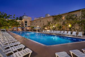 a swimming pool with lounge chairs in front of a building at Plim Plaza Hotel in Ocean City