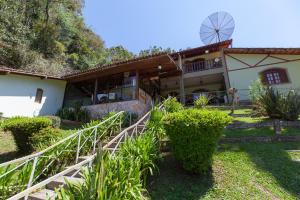 una casa con un molino de viento en el patio trasero en Hotel Shangrila Nova Friburgo, en Nova Friburgo