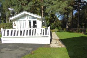 a white bench in a yard with a lawn at Violet 28 Oakdene Forest Park in Ferndown