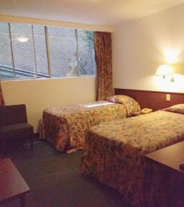 a hotel room with two beds and a window at Hotel Sevilla in Mexico City