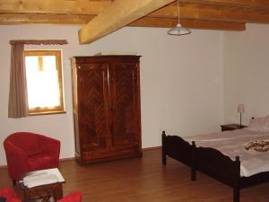 1 dormitorio con 1 cama y armario de madera en Martonvendeghaz 1, en Erdeimajor