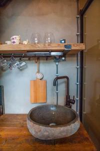 een badkamer met een wastafel en een houten plank bij Goudse Watertoren, ’t kleinste woontorentje van Nederland in Gouda