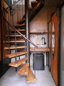 een wenteltrap in een kamer met een wastafel bij Goudse Watertoren, ’t kleinste woontorentje van Nederland in Gouda