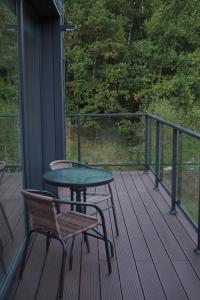 a porch with a table and chairs on a deck at Apartament Berg in Szczyrk