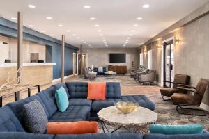 a living room with a blue couch and a table at Plim Plaza Hotel in Ocean City