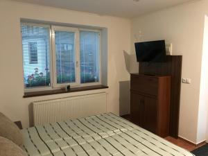 a bedroom with a bed and a flat screen tv at RRR Apartmány in Bojnice
