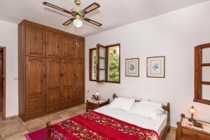 1 dormitorio con 1 cama y ventilador de techo en Charming Country House with View, en Episkopí- Rethimno