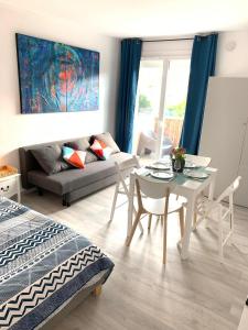 een woonkamer met een tafel en een bank bij Charmant studio avec climatisation et parking in Perpignan