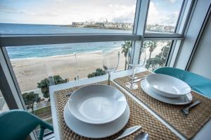 a dining table with a view of the beach at Apartamentos Alocea in A Coruña