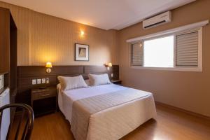 a bedroom with a large bed and a window at Hotel Bahamas in Dourados