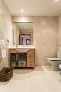 a bathroom with a sink and a toilet and a mirror at Apartamentos Alocea in A Coruña