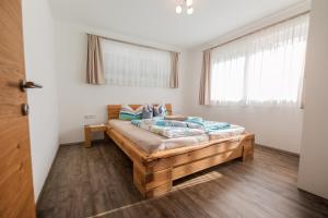 ノイシュティフト・イム・シュトゥーバイタールにあるAppartements Kleeblattのベッドルーム1室(大型木製ベッド1台、青い枕付)