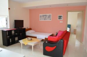 a room with a bed and a couch and a table at Gregory's Apartments in Ksamil