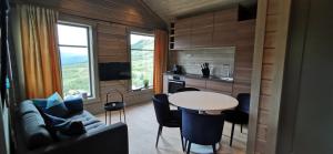 a kitchen and living room with a table and a couch at Timblalodgen - Mountain lodge near Sognefjord & Flåm in Sogndal
