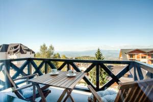 a wooden table on a balcony with a view at Srebrna Petica in Kopaonik