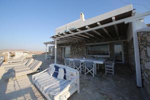 a patio with a table and chairs and a building at Blue Ocean Mykonos in Ornos