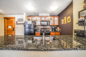 a kitchen with a sink and a refrigerator at White Mountain Lodge #2329 in Mammoth Lakes
