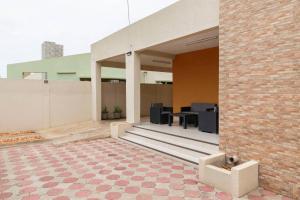 un patio al aire libre con mesa y sillas en un edificio en VILLA PHOEBE Cité BOAD Lomé Baguida en Lomé