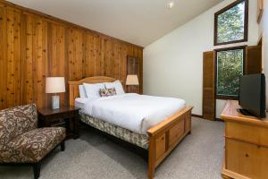 a bedroom with a bed and a tv and a chair at Crescent Ridge by White Pines in Park City