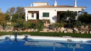 a house with a swimming pool in front of it at Casa Alfazema - Villa Algarvia de Charme in Pechão