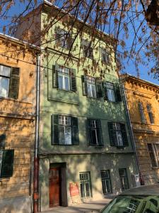 un viejo edificio con persianas verdes. en Kaya Home, en Sibiu