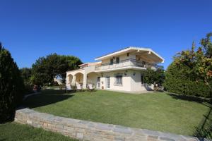 a house with a lawn in front of it at Villa Orestis Melina in Nea Iraklia