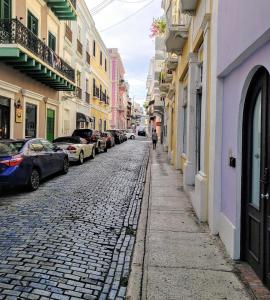 a cobblestone street in a city with parked cars at KASA The Lofts of Old San Juan 201 HUGE 2 bed 2 bath for 6 Washer Dryer in San Juan