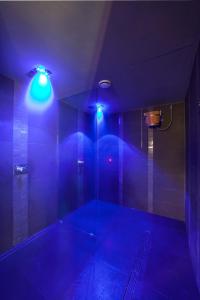 um quarto azul com um chuveiro com luzes azuis em Hotel Touring em Coccaglio