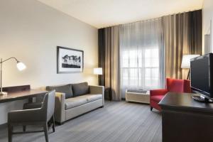 a living room with a couch and a desk in a hotel room at Country Inn & Suites by Radisson, Kearney, NE in Kearney