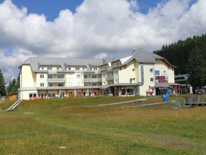 um grande edifício branco com um campo em frente em Ferienresidenz Grafenmatt, Feldberg em Feldberg