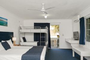 a bedroom with a bunk bed and a desk at Wollongbar Motel in Byron Bay +134 photos