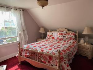 a bedroom with a bed with a red and white comforter at The Inn at Benicia Bay in Benicia