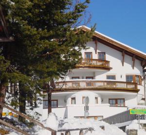 Großes weißes Gebäude mit Balkon in der Unterkunft Hotel Garni Apart Elfriede in Fiss