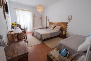 a bedroom with a bed and a desk and a table at Casa do Mar - Nazaré Big Wave Spotter House in Nazaré