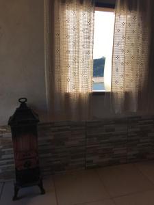 a room with a window and a dresser in front at Chalés Alternativa Sítio in Conceição da Ibitipoca