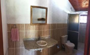 a bathroom with a sink and a toilet and a mirror at Chalés Alternativa Sítio in Conceição da Ibitipoca +23 photos