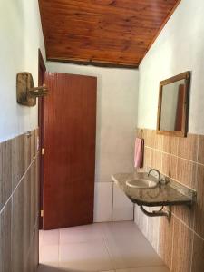 Un baño con lavabo y puerta de madera. en Chalés Alternativa Sítio, en Conceição da Ibitipoca 27 fotos más