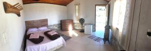 a bedroom with a bed and a large window at Chalés Alternativa Sítio in Conceição da Ibitipoca