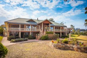 a large house with a landscaping in front of it at Robyn's Nest Lakeside Resort in Merimbula