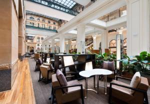 a restaurant with tables and chairs in it at The Fullerton Hotel Sydney in Sydney